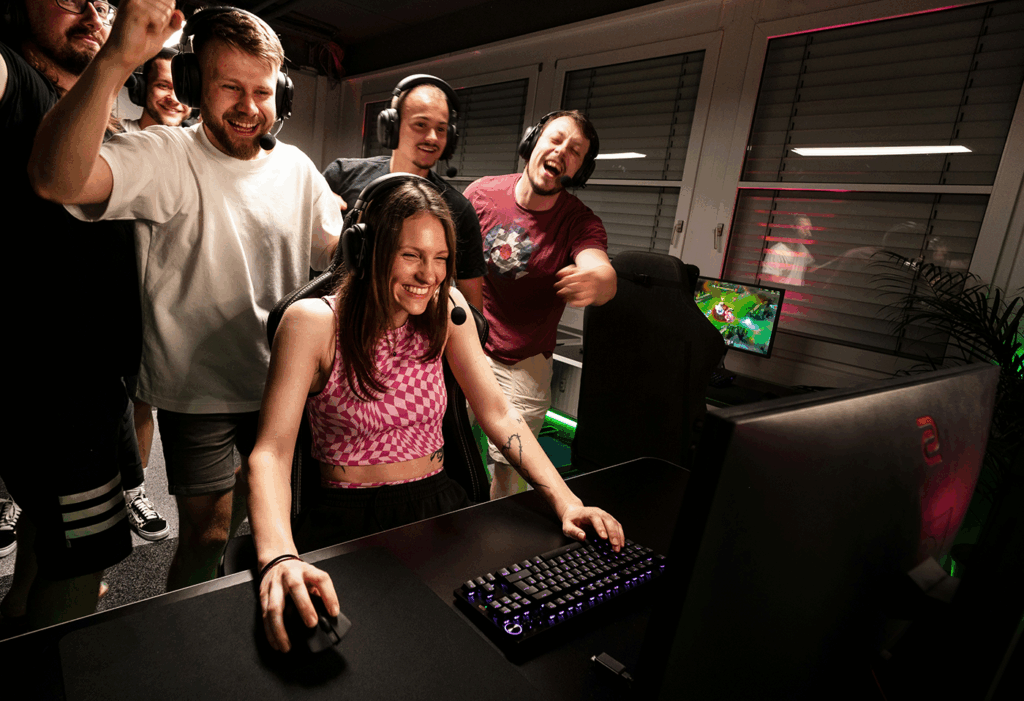 Group of friends enthusiastically supporting a gamer playing on a PC